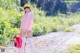 A woman in a pink shirt and white stockings holding a red backpack.