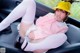 A woman sitting in the back seat of a car wearing a yellow hat.