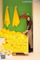 A woman standing in front of a rack of yellow towels.