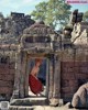 A woman in a red dress standing in a doorway.