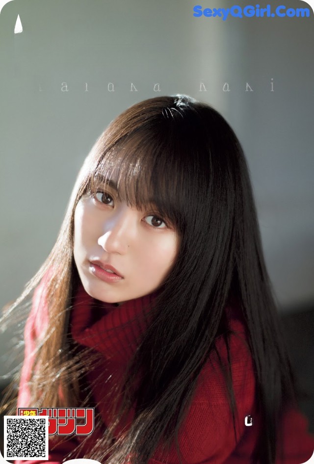 A woman with long black hair wearing a red sweater.