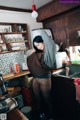 A woman standing in a kitchen next to a sink.