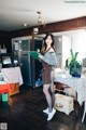 A woman standing in a kitchen holding a book.