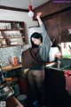 A woman standing in a kitchen holding a brown bag.