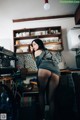 A woman standing in a kitchen next to a stove.