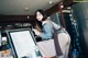 A woman standing in front of a counter holding a cup of coffee.