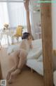 A woman laying on a bed in a white lingerie.