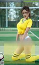 a woman in a yellow shirt is posing with a soccer ball