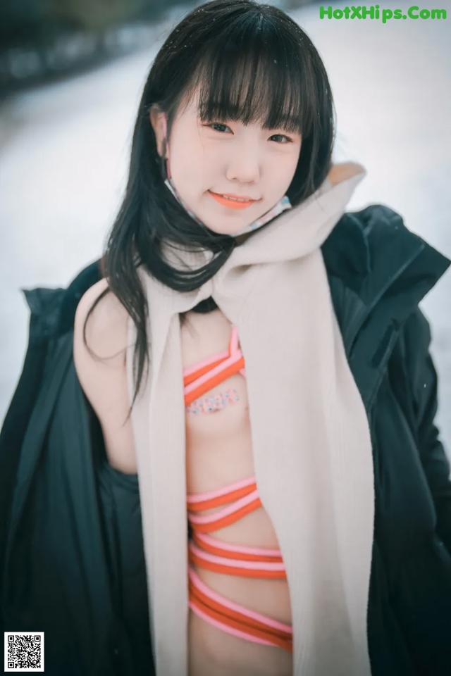 A woman in a bikini and a scarf posing for a picture.