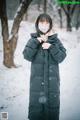 A woman wearing a face mask standing in the snow.