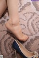 A close up of a woman's feet wearing a pair of blue shoes.