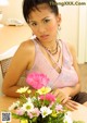 A woman sitting at a table with a bunch of flowers.