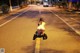 A naked woman kneeling down in the middle of a street.