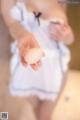 A woman in a white dress holding an egg.