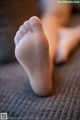 A close up of a person's bare feet on a couch.