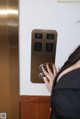 A woman is pressing a button on an elevator.