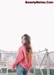 A woman standing on top of a metal fence.