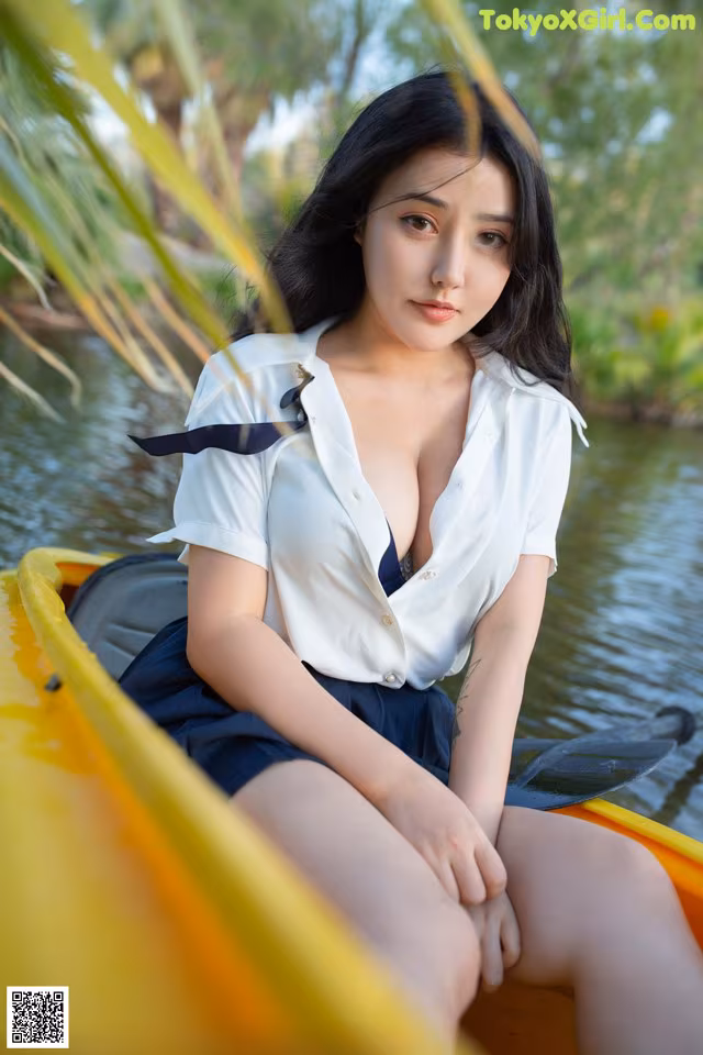 A woman sitting in a yellow canoe on a lake.