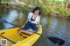 A woman in a yellow kayak paddling down a river.