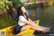 A woman sitting in a yellow kayak on the water.