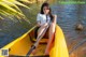 A woman sitting in a yellow canoe on the water.