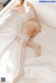 a woman laying on top of a bed in a white lingerie