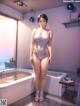 A woman in a bathing suit standing in a bathroom.