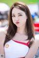 A woman in a red and white dress posing for a picture.