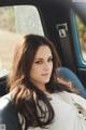 A woman sitting in the back seat of a car.