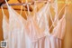 A row of wedding dresses hanging on a wooden hanger.