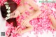 A woman laying on a bed of pink rose petals.