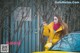 A woman in a yellow coat standing next to a yellow car.