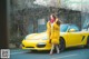 A woman in a yellow coat standing next to a yellow car.