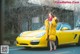 A woman in a yellow coat standing next to a yellow car.