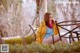 A woman sitting on a bench in a park.