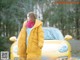 A woman standing in front of a yellow car.