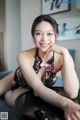 A woman sitting on top of a black table.