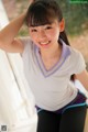 A young woman in a white shirt and black pants posing for a picture.