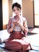 A woman in a kimono sitting on the floor.