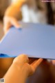 A person holding a piece of blue paper in their hands.