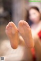 A close up of a person's bare feet on a bed.