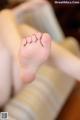 A close up of a person's bare feet on a chair.