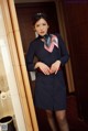 A woman in a blue uniform is posing for a picture.