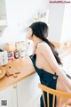 A woman sitting on a chair in a kitchen.