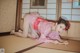 A woman in a pink kimono laying on the floor.