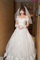 A woman in a wedding dress standing in a hallway.