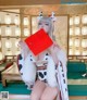 A woman in a cow costume holding up a red envelope.