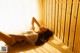 A woman laying on the floor in a sauna.