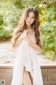 A woman in a white dress posing for a picture.