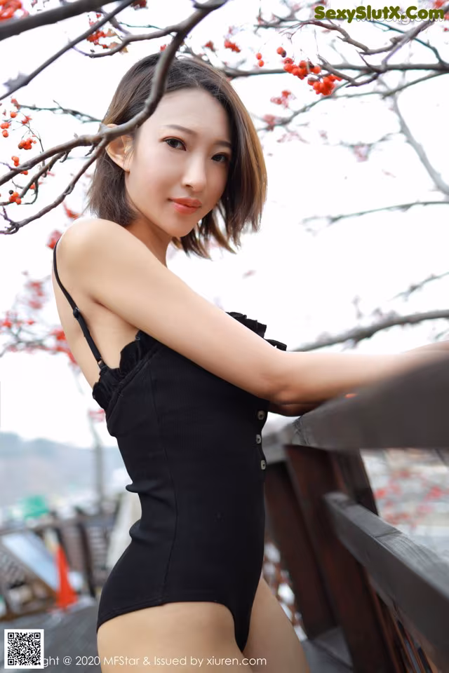 A woman in a black bathing suit posing for a picture.